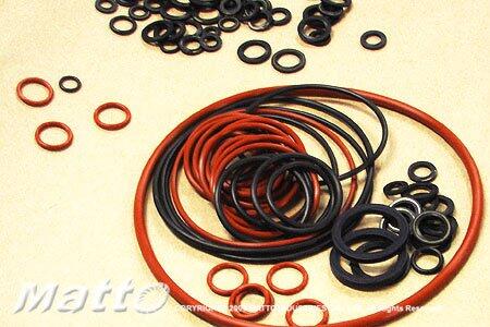 A close-up view of numerous black and reddish-brown O-rings of varying sizes, commonly used as seals and gaskets in various mechanical and industrial applications.